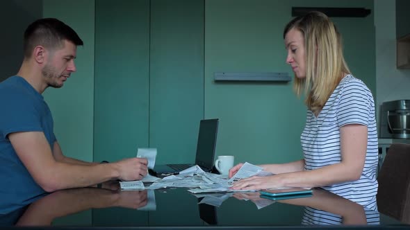 Man and Woman Looking at Payment Bills in the Kitchen alt