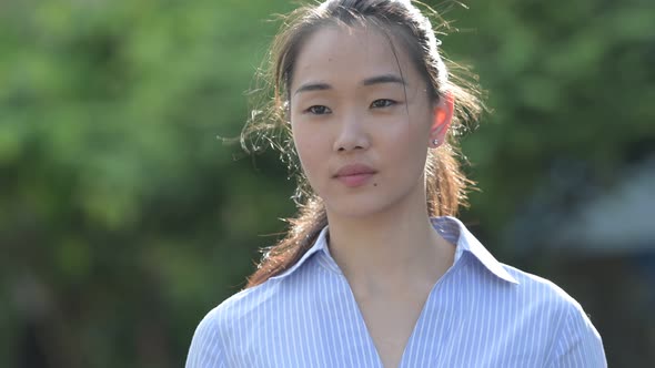 Young Happy Beautiful Asian Businesswoman Thinking Outdoors