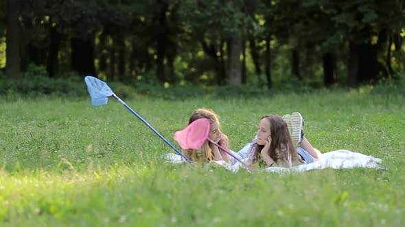 A Group of Happy Children Lying on Green Grass Outdoors in a Spring Park a Tent Camp alt
