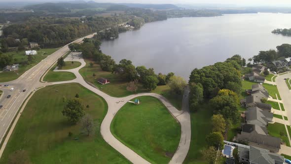 Aerial view of highway along large lake in western Wisconsin. Tree lined shoreline.