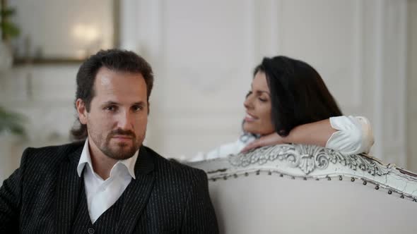 Happy Woman is Looking at Her Serious Husband Romantic Date of Lovers alt