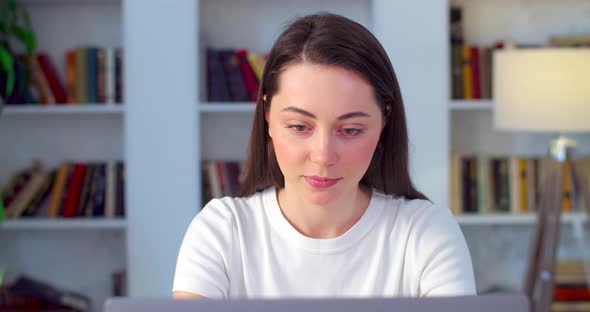 Young Female Student Finishing Work on Computer Laptop Smiling Happily Indoors Apartment Background alt