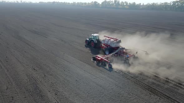 Side View of Tractor Sowing Seeds with Seeder Driller in Field alt
