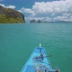 Island Hopping Tour Blue Boat Hover Over Open Blue Ocean Surface Between Exotic Karst Limestone - VideoHive Item for Sale