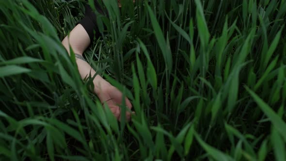 Girl In Black Dress Lies In The Grass. alt