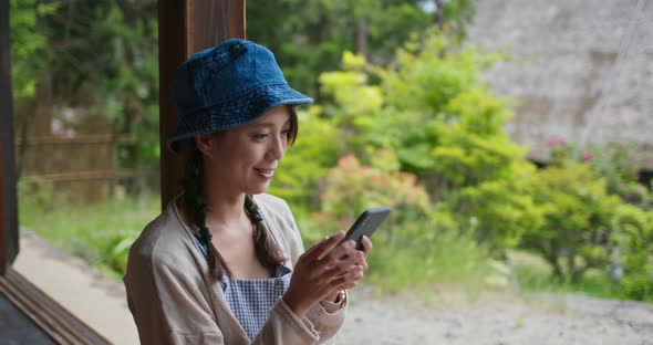Woman use of mobile phone in the old Japanese house alt