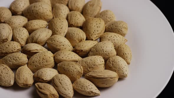 Cinematic, rotating shot of almonds on a white surface  alt