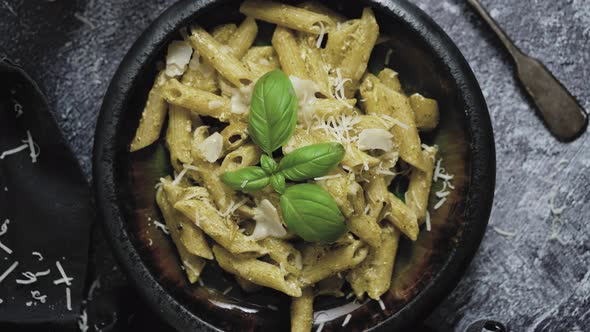 Pasta with Parmesan Cheese and Creamy Pesto Sauce in Black Bowl