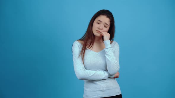 The Portrait of a Sad Girl Who Stands with Her Head in Her Fist Thoughtfully and Thinks What She alt