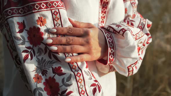 Ukrainian Woman Demonstrating Beautiful Details of Embroidery Ornament on Vyshyvanka Shirt alt