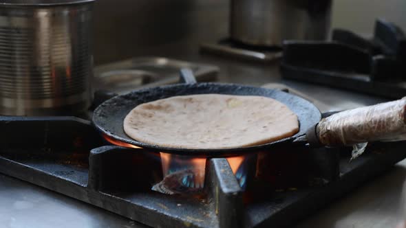 Cooking Indian Dish is Aloo Paratha in a Frying Pan