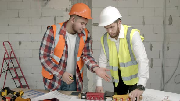 Young Architects Checking Equipment on Construction Site