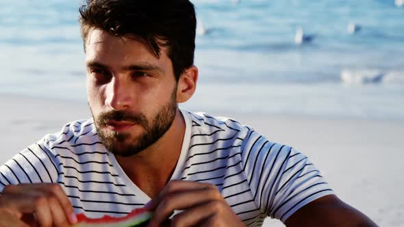 Man having watermelon on the beach alt