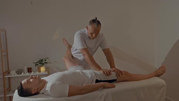 Strong and Concentrated Masseur Therapist in Uniform Making Manual Therapy for Sportsman