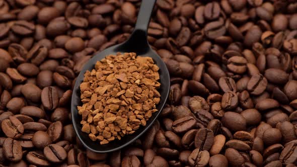 instant coffee in black spoon and coffee beans on background alt