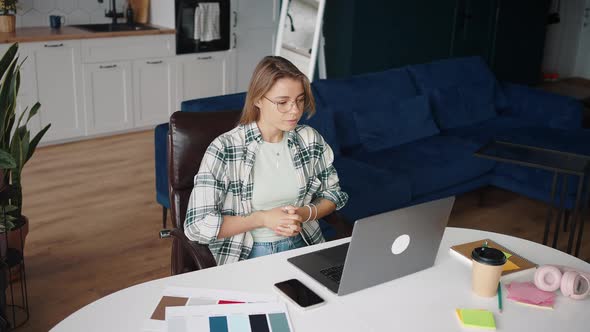Positive Young Lady in Eyeglasses Video Conferencing with Potential Employer Via Laptop Talking alt