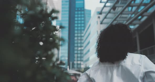 Young woman look at the surrounding buildings, smiles alt
