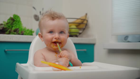 Happy Baby Boy Eating Yellow Mashed Food