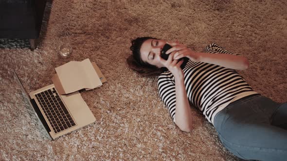 Young adult woman on floor with smart phone