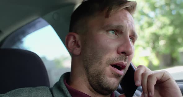Portrait of Man Receives a Phone Call with Yawning in the Car and Nods a Head alt