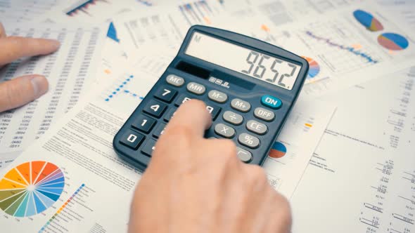 Businessman Counting On The Calculator