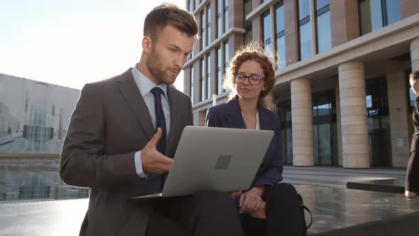 Business Colleagues Discussing Strategy Outdoors alt
