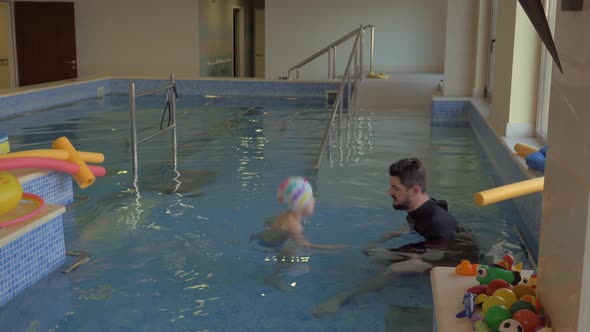 Therapist exercising with a child in the pool alt