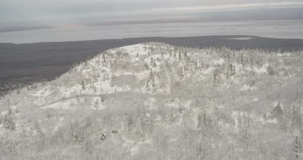 Helicopter aerial shot zooming in and out of buildings in hazy cityscape, sundown