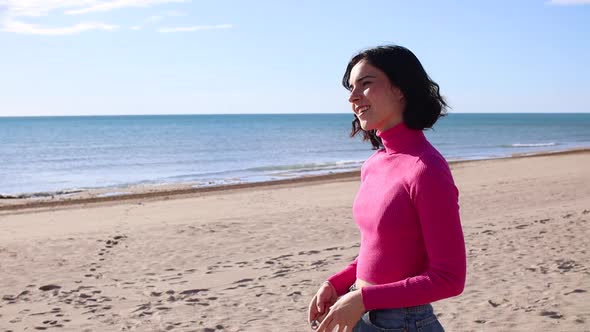Young Woman Takes Pictures Using Portable Camera on the Beach alt