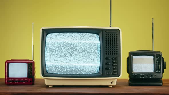 Old Televisions with Grey Interference Screen on Yellow Background alt