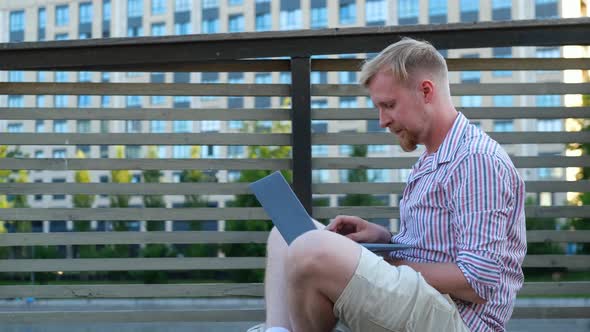 man working on a laptop on the background of the city