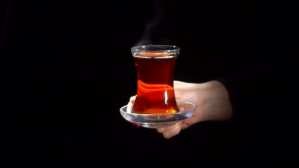 Woman Offering a Glass of Black Tea