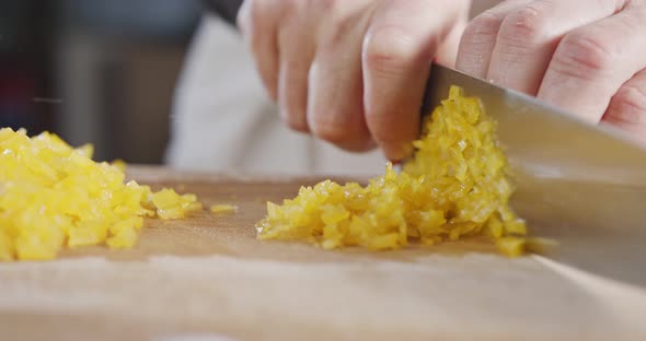 Slow motion close up of a chef knife slicing a yellow bell pepper alt