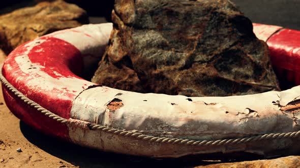 Old Life Buoy on Sandy Beach alt