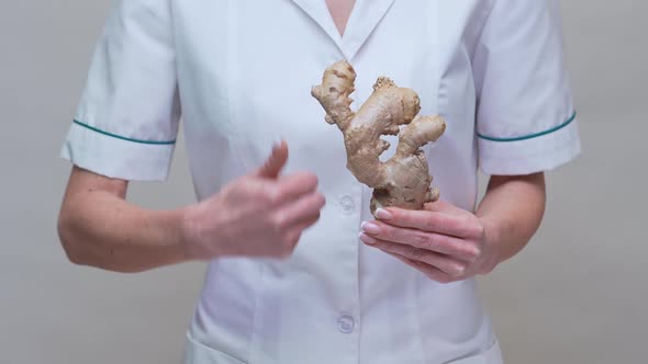 Nutritionist Doctor Healthy Lifestyle Concept - Holding Ginger Root and Medicine or Vitamine Pill alt