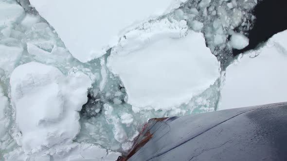 Ship Breaking Through Ice In Antarctica alt
