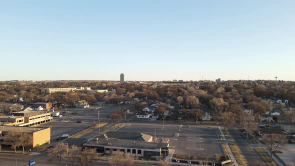 View over small town with large business complex and residential neighborhood with blue sky.