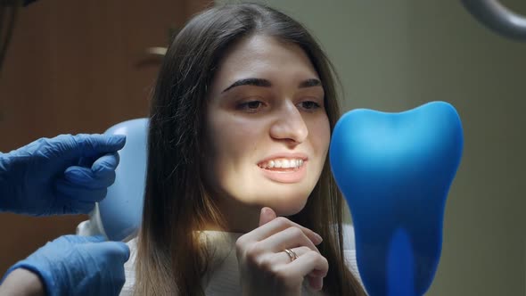 Young Woman Putting on Transparent Plastic Retainers in the Dental Office