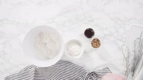Time lapse. Flat lay. Step by step. Ingredients to bake cranberry muffins on a marble kitchen alt