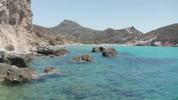 Low Flight Above Turquoise Blue Ocean Water and Rocky Cliff Coast in Greece alt