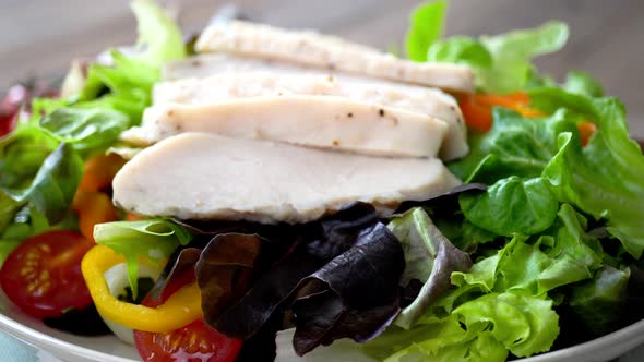 Colorful fresh homemade healthy salad with boiled chicken breast, closed up dolly shot