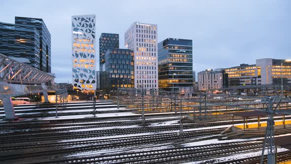 Train Leaving Oslo Central Station With Barcode Project Buildings At Night In Bjorvika, Oslo, Norway alt