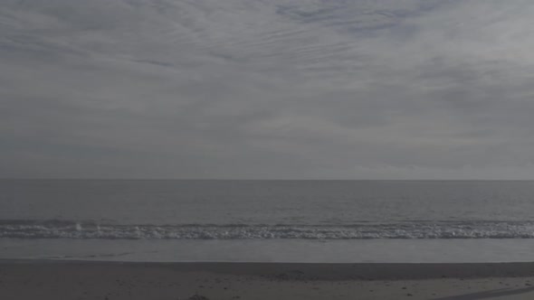 A young woman running on the beach. alt