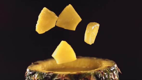 Pineapple Pieces Falling on the Surface of Half Pineapple in Slow Motion alt