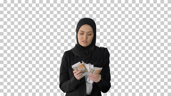 Pretty woman in hijab walking and counting money, Alpha Channel alt