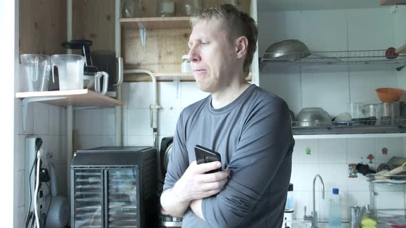 Thoughtful Caucasian Man Standing at Old Soviet Kitchen Speaking to Himself