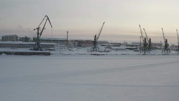 Cranes of the River Port Against the Background of the Arctic City of NaryanMar