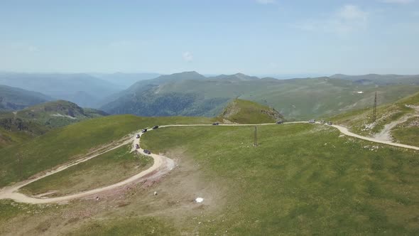 Aerial view of a group of cars rides along the mountains Kolasin in spring in Montenegro. alt
