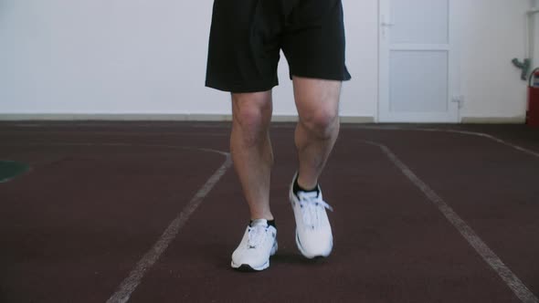 Unrecognizable Runner Training Running Exercise on Treadmill in Gym Front View