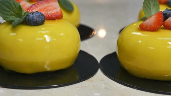 Dolly Shot of Yellow Mousse Desserts with Berries